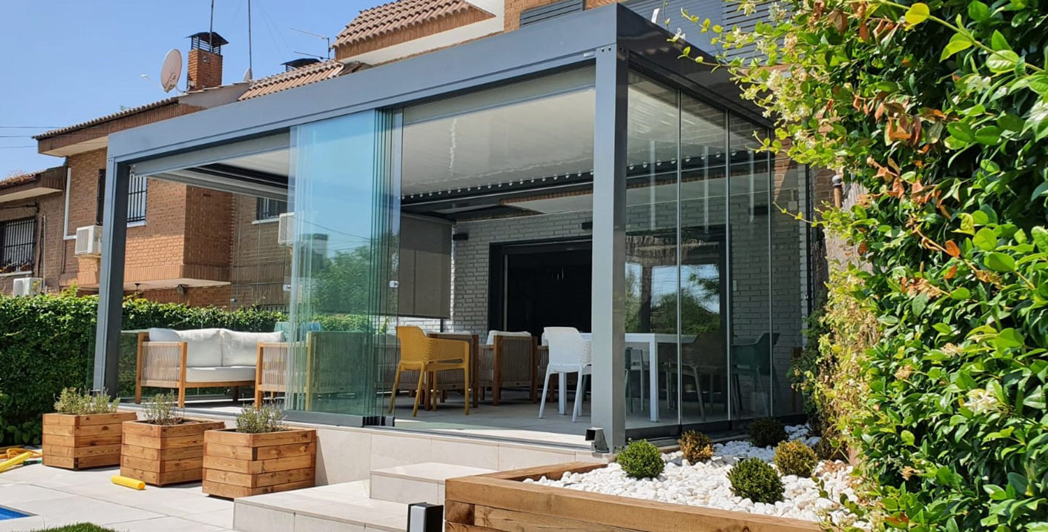 Pérgola bioclimática con cortina de cristal